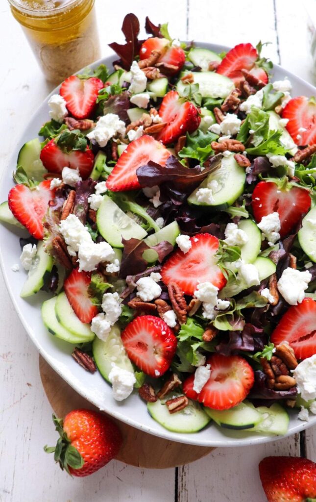 Mixed salad with sliced strawberries and goat cheese